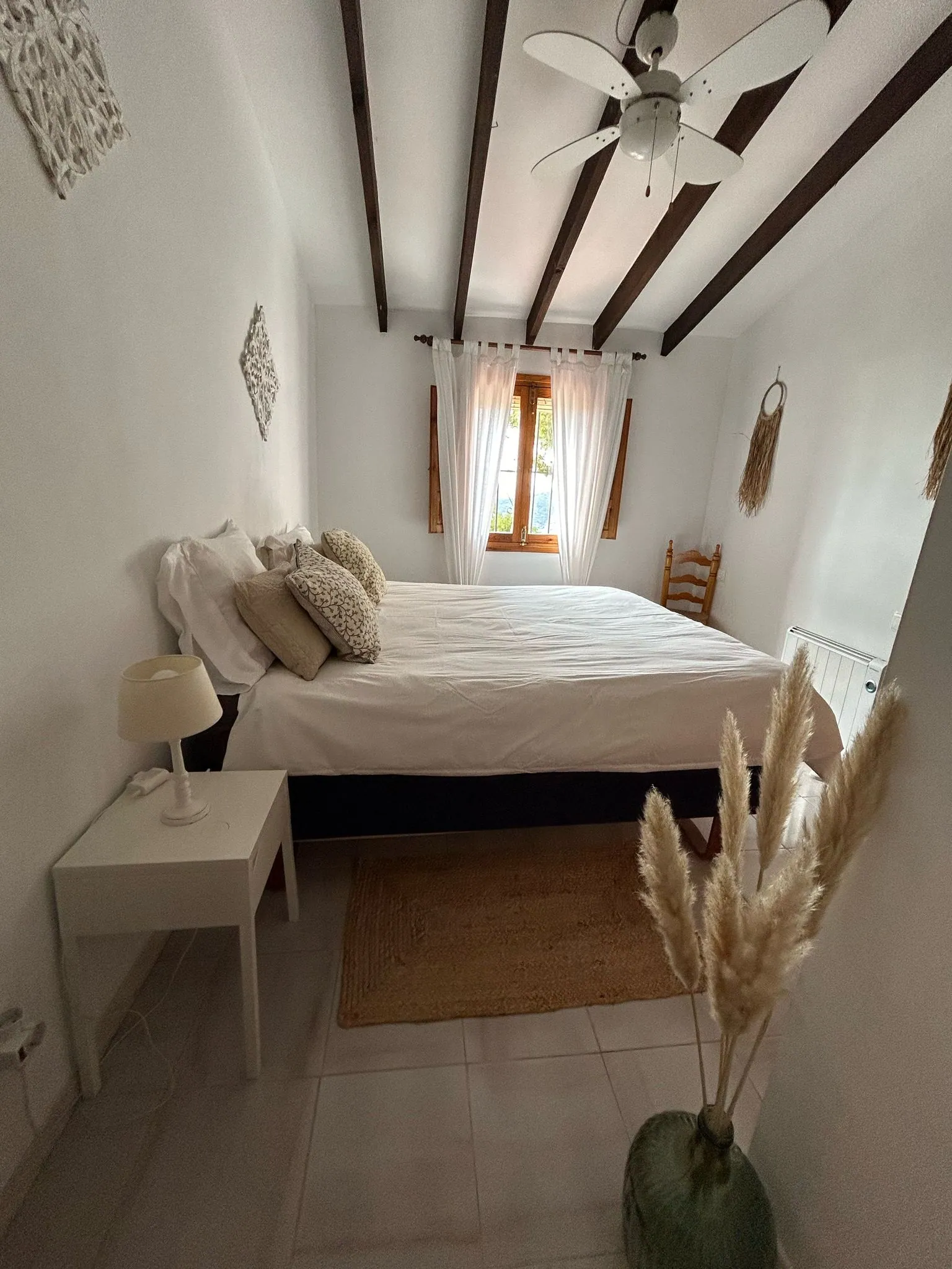 Double bedroom with exposed beams and a ceiling fan